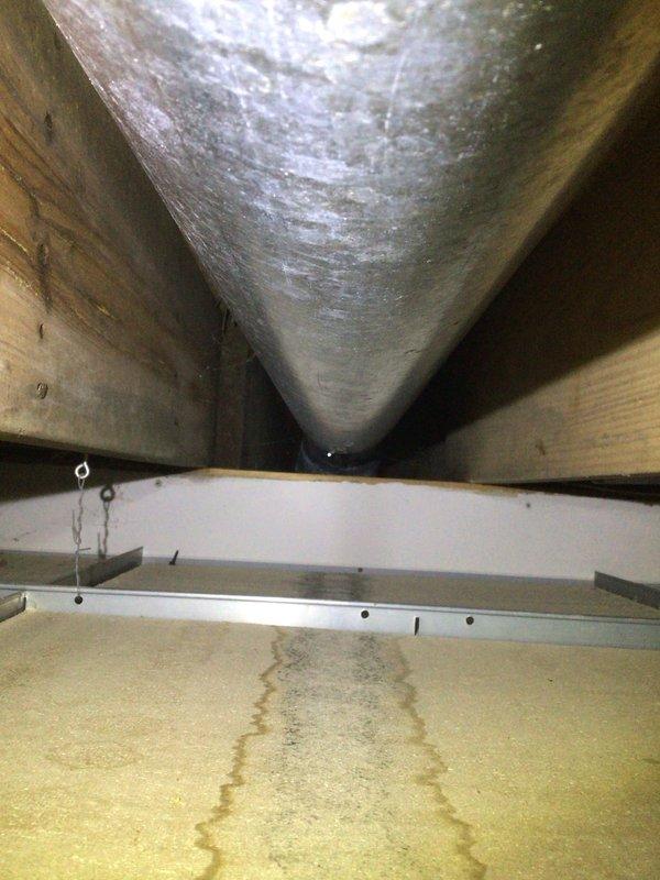 Responded to service call for excessive condensation on lower level supply duct causing water damage to ceiling panels. Upon inspection, found inadequate insulation on cold air supply duct in crawl space, resulting in significant sweating and moisture accumulation on duct surface. Documented existing water damage to insulation material beneath affected ductwork. Provided recommendations for proper duct insulation replacement and vapor barrier installation to prevent future condensation issues and protect surrounding building materials.