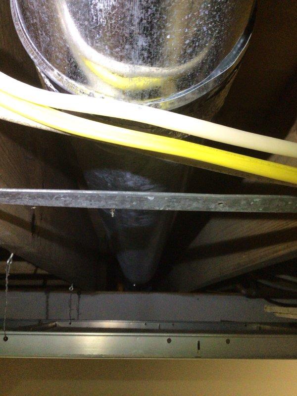 Responded to service call for excessive condensation on lower level supply duct causing water damage to ceiling panels. Upon inspection, found inadequate insulation on cold air supply duct in crawl space, resulting in significant sweating and moisture accumulation on duct surface. Documented existing water damage to insulation material beneath affected ductwork. Provided recommendations for proper duct insulation replacement and vapor barrier installation to prevent future condensation issues and protect surrounding building materials.