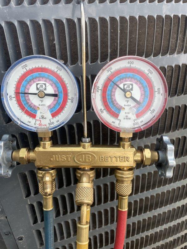 Completed comprehensive cooling system tune-up on residential AC unit located at side of home. Performed refrigerant pressure analysis using manifold gauge set, verifying proper system charge and operating pressures across both high and low sides. Inspected condenser coil fins, which were found to be clean and in good condition. Examined electrical components, circuit breakers, and wiring connections within the air handler cabinet, confirming all connections were secure and system controls were functioning properly.