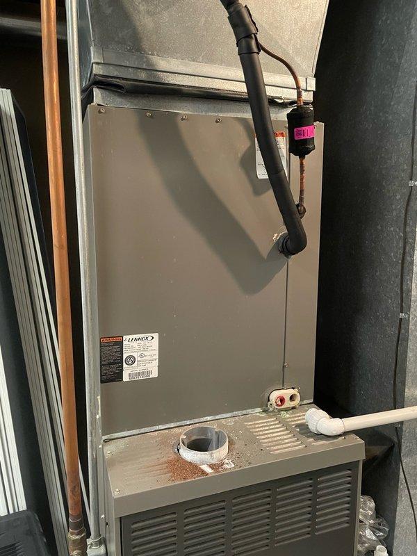 Completed evaporator coil replacement on Lennox HVAC system with serial number 6007E13300. Removed failed coil and installed new coil assembly, reconnected refrigerant lines, and verified proper drainage through condensate pan and PVC drain line. System tested and confirmed operational for both heating and cooling modes.