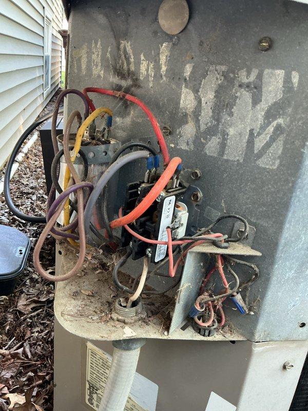 Completed comprehensive cooling system tune-up on 31-year-old ground-level AC unit. Performed full system inspection including condenser coil cleaning, electrical connection evaluation, capacitor testing, and refrigerant line assessment. Unit showing significant age-related weathering and corrosion on exterior panels and internal components, but all systems operational following maintenance service.