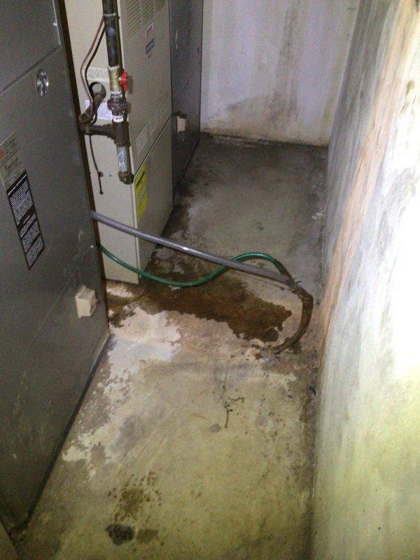 Performed comprehensive diagnostic on upstairs HVAC unit addressing no airflow from supply vents. Inspected downstairs unit for reported water discharge issue, identifying active condensate drainage concerns and evidence of previous moisture damage to basement floor and surrounding areas. Documented system conditions with photos showing both furnace installation and water heater/HVAC equipment configuration, noting staining patterns on concrete floor and copper piping connections requiring attention.