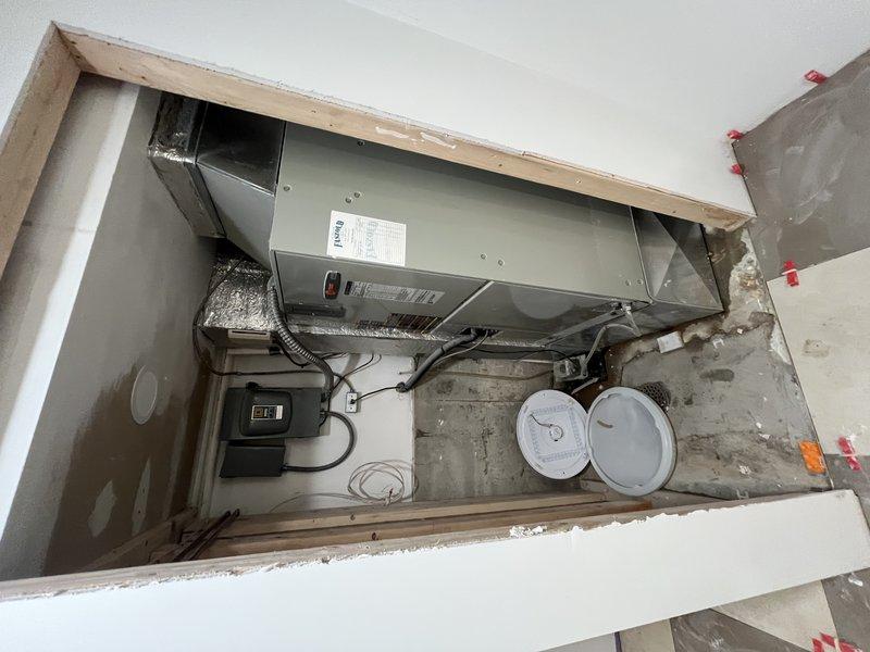 Responded to service call for frozen air conditioning unit that had been turned off by customer. Upon arrival, accessed property and performed system inspection of ceiling-mounted air handler installation. Evaluated HVAC unit housing, ductwork connections, electrical control box, and associated wiring. Documented equipment condition including metallic ductwork with flexible insulation wrapping and observed minor surface corrosion on ventilation components. Unit assessed following thaw period to determine root cause of freezing condition and verify proper system operation.