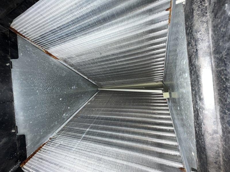Responded to service call for frozen air conditioning unit that had been turned off by customer. Upon arrival, accessed property and performed system inspection of ceiling-mounted air handler installation. Evaluated HVAC unit housing, ductwork connections, electrical control box, and associated wiring. Documented equipment condition including metallic ductwork with flexible insulation wrapping and observed minor surface corrosion on ventilation components. Unit assessed following thaw period to determine root cause of freezing condition and verify proper system operation.