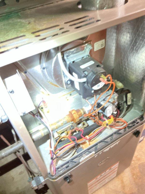 Responded to a failed inspection on a 14-year-old furnace system located in the basement. Upon arrival, identified that the gas pipe union was positioned inside the structure and required relocation to the exterior to meet code compliance. Documented the existing configuration of the HVAC unit, including internal blower assembly, electrical wiring, and associated gas piping with shutoff valve, to establish a baseline for the required modifications.