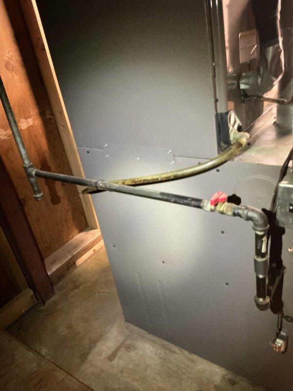 Responded to a failed inspection on a 14-year-old furnace system located in the basement. Upon arrival, identified that the gas pipe union was positioned inside the structure and required relocation to the exterior to meet code compliance. Documented the existing configuration of the HVAC unit, including internal blower assembly, electrical wiring, and associated gas piping with shutoff valve, to establish a baseline for the required modifications.