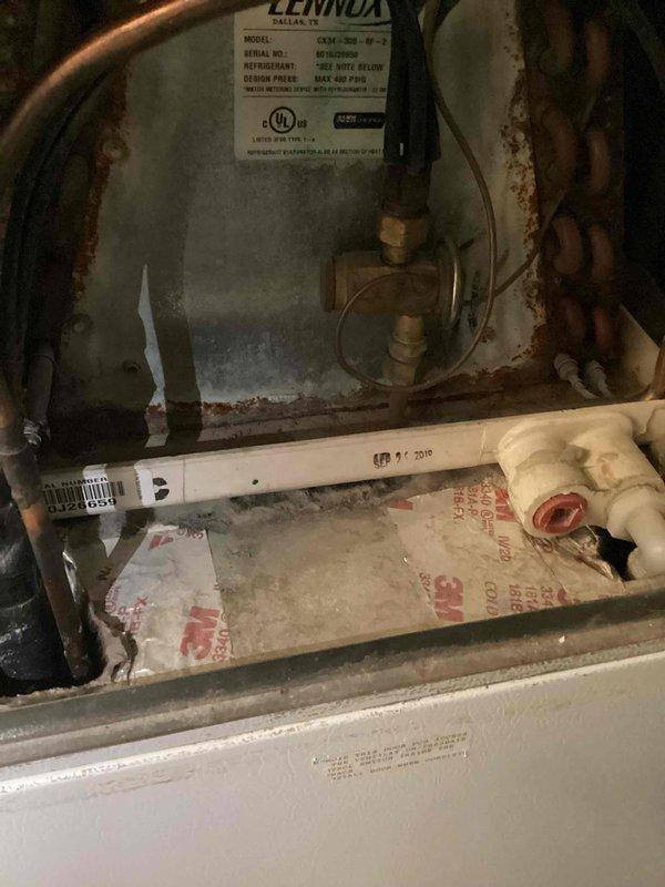 Responded to cooling inadequacy complaint on residential air conditioning system. Performed diagnostic evaluation on Lennox CDJX-306-W-2 unit utilizing Fieldpiece SMAN manifold gauge set to measure system pressures and temperatures on R-22 refrigerant system. Unit interior showed significant age-related deterioration including rust staining and copper line discoloration, indicating need for further assessment of system performance and potential refrigerant charge issues.