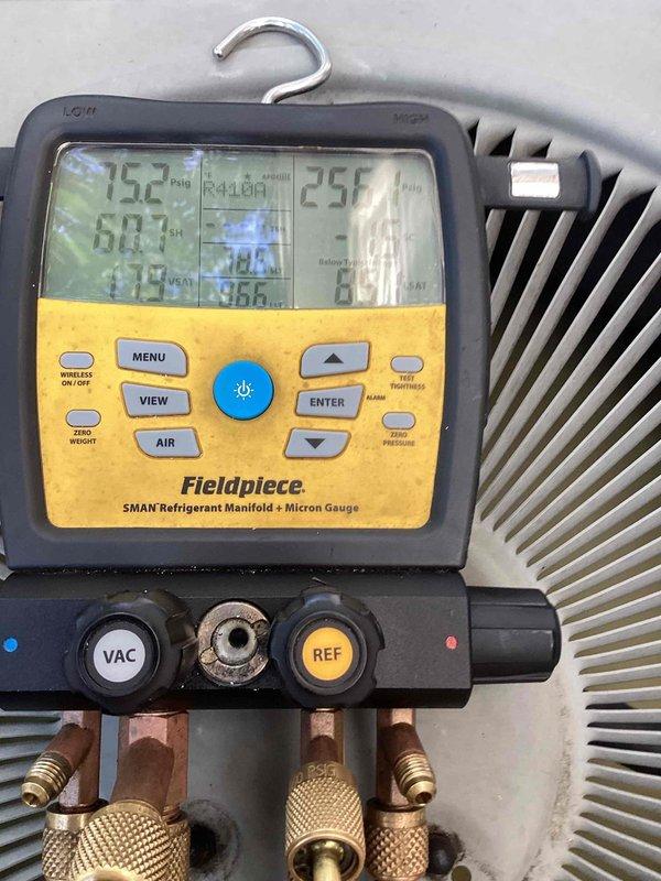 Responded to cooling inadequacy complaint on residential air conditioning system. Performed diagnostic evaluation on Lennox CDJX-306-W-2 unit utilizing Fieldpiece SMAN manifold gauge set to measure system pressures and temperatures on R-22 refrigerant system. Unit interior showed significant age-related deterioration including rust staining and copper line discoloration, indicating need for further assessment of system performance and potential refrigerant charge issues.