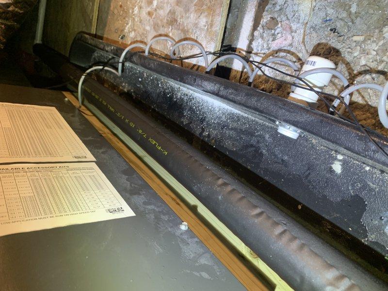 Responded to no-cool call on recently installed Lennox/Goodman system under first-year warranty. Upon arrival, confirmed thermostat communication was functioning but unit would not start. Performed diagnostic inspection of indoor air handler and coil assembly in attic space. Observed active condensation on evaporator coil and drain pan, indicating proper refrigerant charge when system operational. Inspected electrical connections, control board, and safety switches. Documented system conditions with photographs showing equipment installation, ductwork configuration, and condensate management. Troubleshot communication and control circuit between thermostat and air handler to identify startup failure cause.