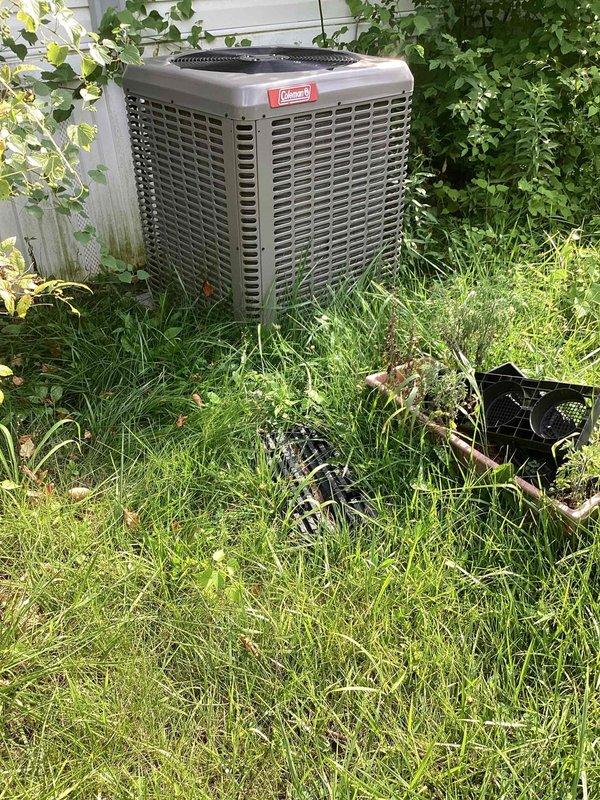 Responded to no-cooling complaint for master bedroom in residential split system. Upon arrival, found Coleman condenser unit with damaged/detached fan guard and protective top grille lying in grass around unit. Inspected system and determined fan guard failure allowed debris access and compromised airflow to condenser. Reinstalled protective components, cleared vegetation from around unit perimeter, verified proper condenser fan operation, and restored cooling function to affected zone.