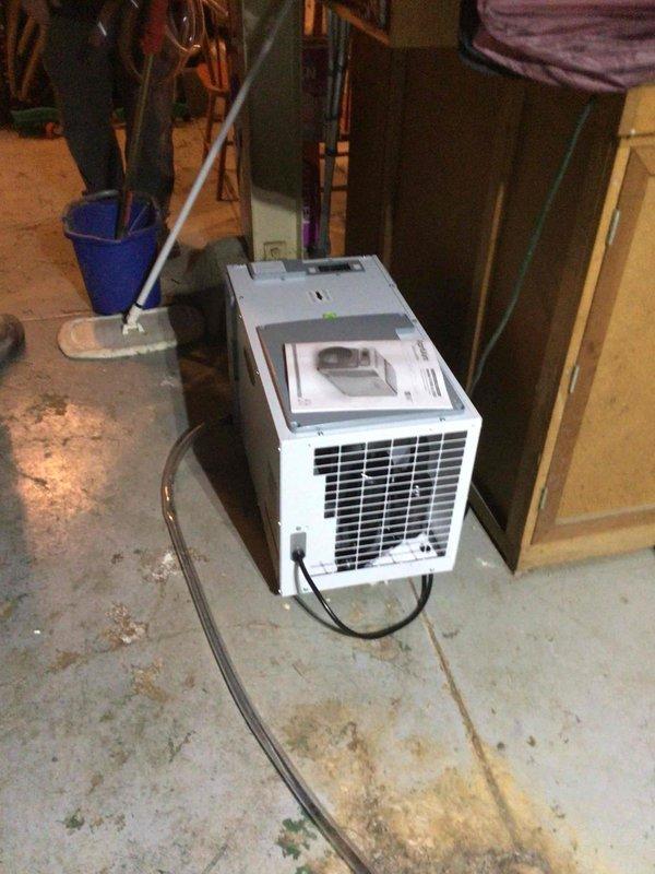 Installed portable dehumidifier unit in basement utility area and connected drainage hose to existing floor drain for condensate removal. Verified unit operation and proper drainage flow. System is functioning as designed to control humidity levels in the space.
