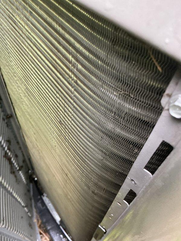Responded to no-cooling call on residential split system air conditioning unit. Upon arrival, performed diagnostic evaluation of outdoor condenser unit and indoor evaporator coil assembly. Inspected evaporator coil and found significant dust and debris accumulation on fin surfaces, particularly affecting airflow efficiency. Examined outdoor condensing unit positioned on pad at side of residence, noting copper refrigerant lines and overall unit condition. Utilized diagnostic testing equipment to assess system performance and electrical components. Completed thorough inspection of both indoor and outdoor components as part of comprehensive cooling system evaluation. Unit operational following diagnostic service.