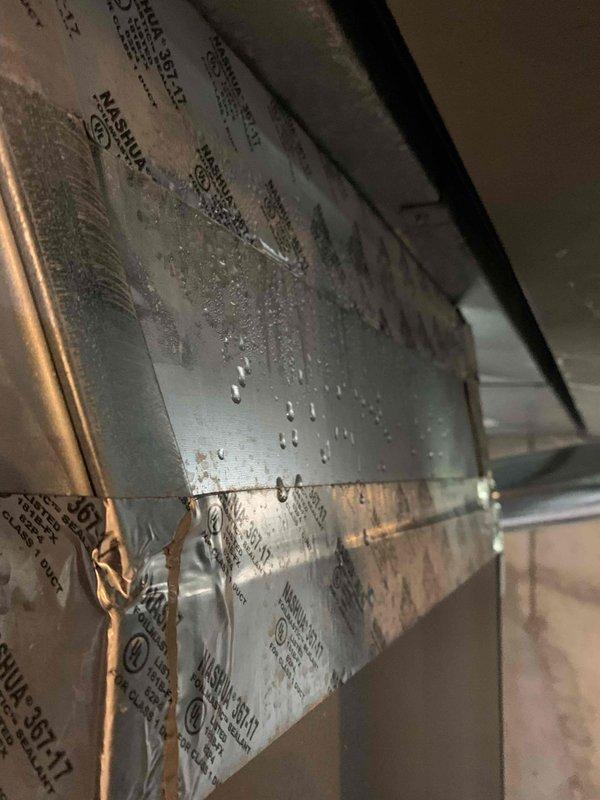 Performed diagnostic service on 1-year-old residential air conditioning system experiencing excessive condensation issues and resulting air filter clogging. Upon inspection, discovered significant moisture accumulation on indoor HVAC ductwork and equipment surfaces, with visible water droplet formation indicating improper temperature differential or airflow concerns. Evaluated refrigerant charge levels, inspected condensate drainage system, and assessed indoor air handler and outdoor ground-level condenser unit operation. Documented conditions with photographic evidence showing condensation on metal ductwork panels and exterior unit installation. Contacted customer to review diagnostic findings and discuss recommended repairs to resolve moisture-related performance issues affecting system efficiency and indoor air quality.