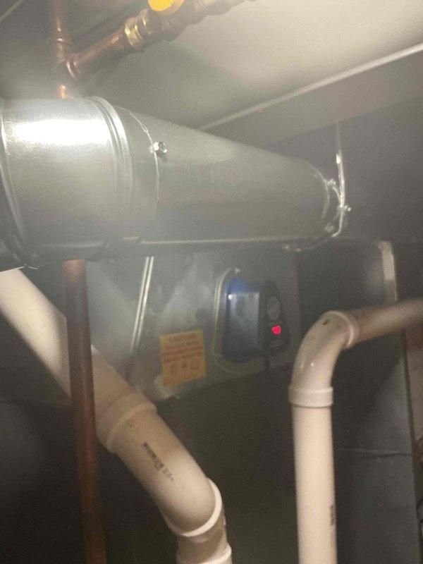 Addressed water heater flue installation and provided technical consultation regarding flue liner requirements. After thorough inspection and assessment of the existing HVAC system and water heater configuration, determined that flue liner installation was not necessary for this application. Responded to customer inquiries and concerns about proper venting requirements, explaining code compliance and safety considerations. Documented equipment condition and current installation with photographs showing air handler unit, condensing unit with refrigerant lines, PVC condensate drainage, and furnace with existing vent piping configuration in mechanical space.