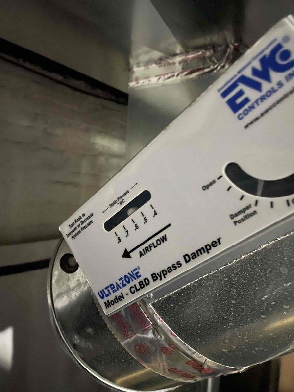 Responded to service call for inadequate cooling on upper level of residence with 9-year-old air conditioning system. Performed comprehensive system evaluation and inspected zoning components. Found HVAC ULTRAZONE Model CLED bypass damper installed on main supply duct with adjustable damper position control. Inspected control board (Model CL-45) and verified all electrical connections, fuses, and safety circuits functioning properly. Discussed airflow balancing options and zoning system optimization with customer to improve upper level temperature control. Provided professional assessment of current system capabilities and consulted with customer regarding supplemental cooling alternatives including window unit options for enhanced comfort in specific areas.