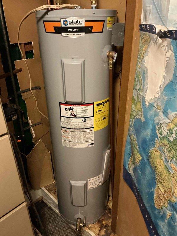 Installed a 40-gallon electric State ProLine Commercial Grade tanked water heater in utility closet. Unit positioned on white drain pan per code requirements, with all copper supply line connections and brass fittings properly secured at top of tank. Installation completed with digital control panel operational and all manufacturer labels intact for future reference.
