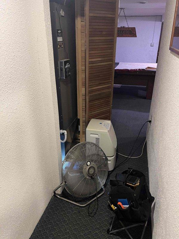 Responded to water leak from HVAC equipment in basement. Upon arrival, found evidence of significant moisture damage to wooden structures and copper piping showing deterioration from prolonged water exposure. Deployed air mover and dehumidifier to begin drying affected hallway area and mitigate further moisture damage. Inspected 6-year-old system components and identified source of leak. Documented conditions with photos showing extent of water damage to surrounding materials and compromised building envelope where mechanical systems are located.
