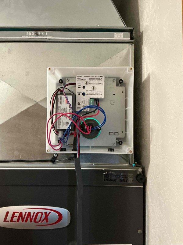 Responded to service call for non-operational whole-house UV air purification system. Upon arrival, inspected UV unit mounted to HVAC ductwork and accessed control panel to diagnose issue. Found UV system control module and wiring connections; verified power supply and checked electrical connections within junction box. Documented equipment configuration including UV lamp housing mounted to supply duct adjacent to Lennox HVAC unit. System evaluated and photographed for service records.
