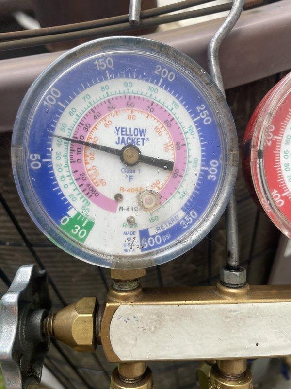 Responded to emergency service call for non-cooling residential air conditioning system. Connected manifold gauge set to measure R-410A refrigerant pressures and confirmed low refrigerant charge. Added refrigerant to system to restore temporary cooling capacity while customer awaits scheduled equipment replacement, bringing system pressures within acceptable operating range and restoring functionality to thermostat.