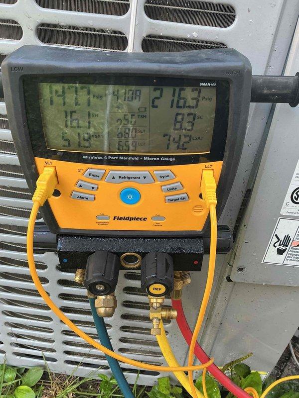 Responded to no cooling complaint on residential air conditioning system less than 10 years old located in side yard. Upon arrival, confirmed unit was running but delivering warm air to occupied space. Connected digital manifold gauges to service ports and performed comprehensive system diagnostics including pressure and temperature measurements across refrigerant circuit. Analysis revealed system operating pressures and superheat/subcooling values outside manufacturer specifications. Documented all readings with digital manifold displaying real-time data for both high and low side pressures. Identified refrigerant charge issue affecting cooling capacity and system performance, preventing proper heat transfer at evaporator coil and resulting in warm air discharge from supply registers.