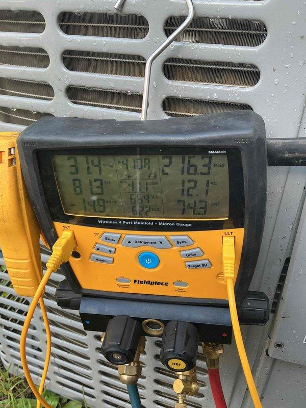 Responded to no cooling complaint on residential air conditioning system less than 10 years old located in side yard. Upon arrival, confirmed unit was running but delivering warm air to occupied space. Connected digital manifold gauges to service ports and performed comprehensive system diagnostics including pressure and temperature measurements across refrigerant circuit. Analysis revealed system operating pressures and superheat/subcooling values outside manufacturer specifications. Documented all readings with digital manifold displaying real-time data for both high and low side pressures. Identified refrigerant charge issue affecting cooling capacity and system performance, preventing proper heat transfer at evaporator coil and resulting in warm air discharge from supply registers.