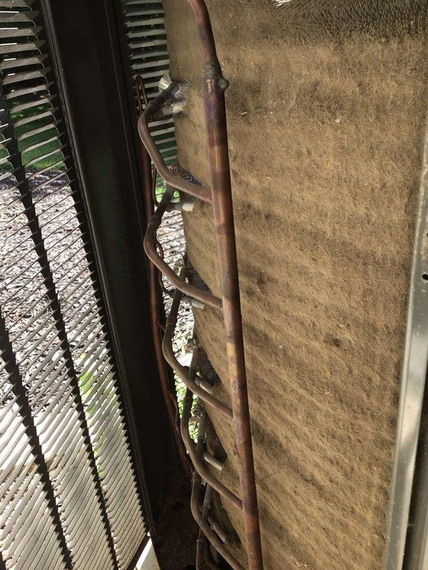 Responded to report of knocking noise from outdoor AC unit. Upon inspection, found condenser unit operational with accessible exterior-mounted components showing age-related oxidation on refrigerant lines. Identified heavily soiled air filter as contributing factor to system stress. Replaced dirty pleated filter and inspected copper refrigerant piping connections for secure mounting to eliminate potential noise source from loose components or vibration against mounting surface.