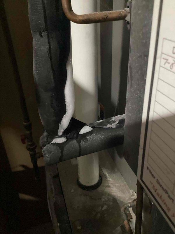 Responded to no cooling complaint affecting entire residence. Upon arrival, performed system inspection and discovered severe frost and ice accumulation on refrigerant lines at indoor air handler unit. Heavy frost buildup observed on both suction line (large insulated pipe) and liquid line connections, indicating restricted airflow or low refrigerant charge causing evaporator coil to freeze.

Inspected outdoor condensing unit and associated refrigerant piping. Found evidence of possible refrigerant leak or system restriction. Checked condensate drain line for proper operation. System was shut down to allow ice to thaw completely before further diagnostics could be performed.

Advised customer that frozen evaporator coil must fully defrost before accurate system testing and diagnosis can occur. Recommended follow-up visit to check refrigerant charge levels, test airflow across evaporator coil, inspect air filter condition, and verify proper system operation once ice has melted. Took dia