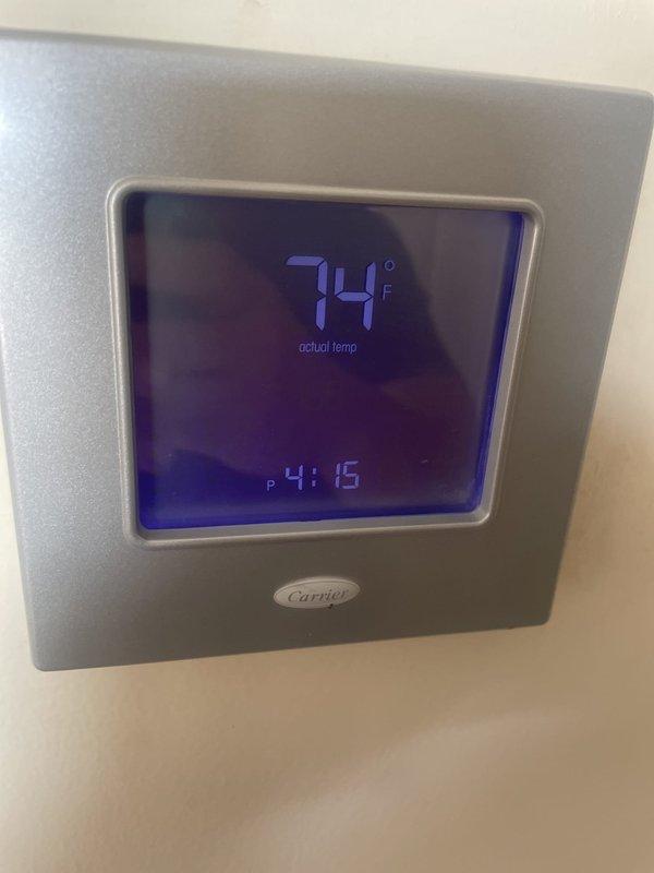 Responded to service call for Carrier thermostat failing to cycle off air conditioning system when set temperature was reached, resulting in overcooling. Inspected 15-year-old rooftop unit and evaluated thermostat programming and calibration settings. Documented existing thermostat configuration showing temperature differential and cycling parameters for diagnostic purposes.