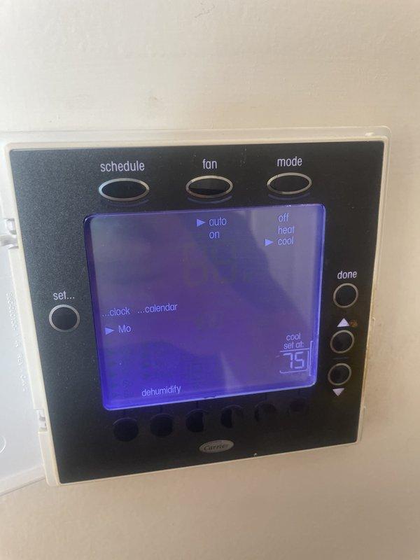 Responded to service call for Carrier thermostat failing to cycle off air conditioning system when set temperature was reached, resulting in overcooling. Inspected 15-year-old rooftop unit and evaluated thermostat programming and calibration settings. Documented existing thermostat configuration showing temperature differential and cycling parameters for diagnostic purposes.