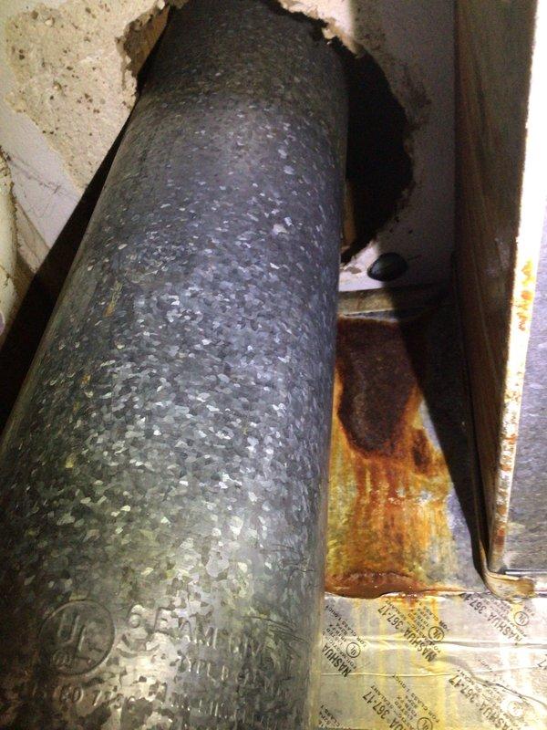 Responded to no-cool call with water dripping from ceiling near indoor air handler on Lennox system installed December 2022. Upon inspection, discovered condensate drainage issue causing water overflow from the air handler unit. Found evidence of water staining on insulation material surrounding ductwork penetration through wall cavity, indicating active leak when system operates. Inspected condensate drain line routing and PVC drainage system for blockages or improper pitch. Verified air handler cabinet installation and condensate pan condition. Documented system configuration including furnace, ductwork connections, and copper refrigerant line routing. Photographed affected areas showing water damage patterns on insulation and mechanical space layout for warranty documentation purposes. System evaluated for proper drainage function to prevent further ceiling water intrusion during cooling operation.