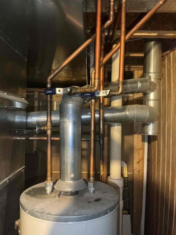 Completed installation of 50-gallon tall gas-fired water heater in residential utility space. Connected copper supply lines with proper shutoff valves, installed gas piping with code-compliant black iron pipe and shut-off valve, and attached pressure relief valve with discharge piping. All plumbing connections were secured and tested for proper operation and leak-free performance.