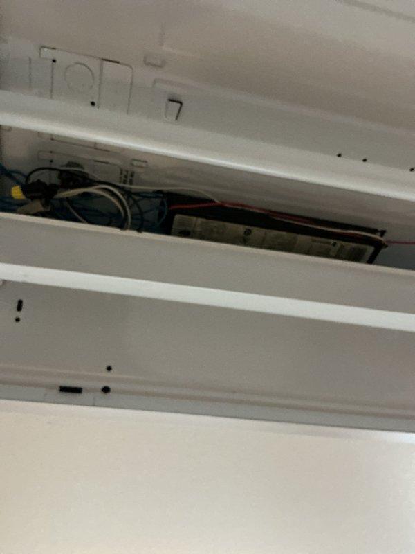 Completed comprehensive electrical inspection of residential property focusing on exposed wiring systems in attic space and HVAC electrical connections. Inspected bundled yellow electrical cables and white communication wiring running along structural beams, verified proper mounting of junction boxes and cylindrical fixtures, and examined conduit installations. Evaluated internal electrical components of wall-mounted HVAC unit, including motor housing, control wiring, and connection integrity. All systems found to be properly installed and functioning within normal parameters.