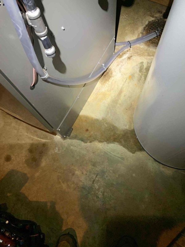 Responded to callback for air conditioning unit not cooling following previous service appointment. Upon arrival, discovered water heater leakage in basement causing excessive humidity levels affecting HVAC system performance. Documented extensive water damage on concrete floor around dual water heater installation with visible staining and moisture accumulation. Advised customer that plumbing issue must be resolved and basement humidity controlled before air conditioning system can operate effectively.