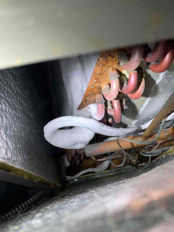 Responded to report of inadequate cooling in bedroom system. Upon inspection, found extensive rust and corrosion on critical mounting bracket components within the air handler compartment, indicating prolonged moisture exposure that could compromise system integrity and performance. Verified thermostat operation showing system calling for cooling at 69°F setpoint. Documented conditions with photos and contacted customer with diagnosis of corroded internal components requiring attention to restore proper cooling efficiency and prevent potential system failure.