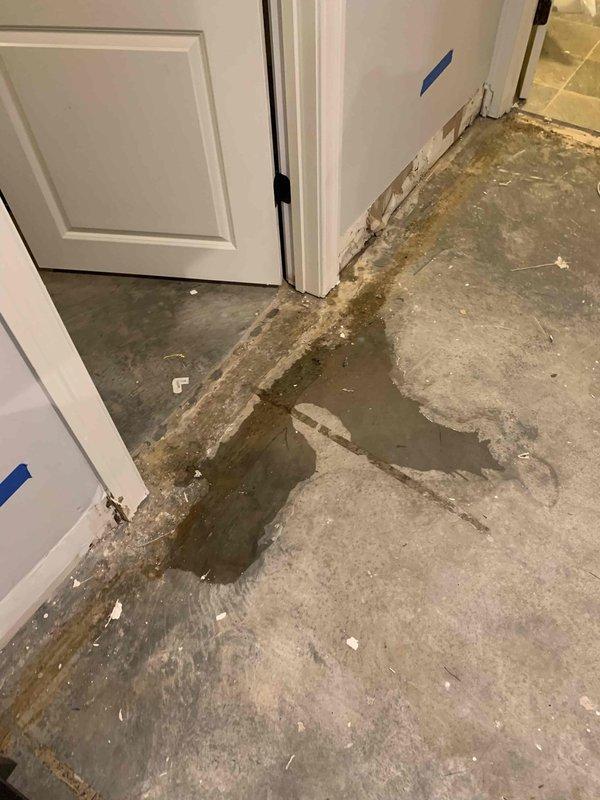 Responded to service call for water leakage from basement A/C unit. Upon inspection, discovered active condensate drainage issue causing significant water accumulation on concrete floor with visible staining and moisture damage along baseboards and wall corners. Inspected 10-year-old air handler and associated mechanical systems in basement utility area. Identified compromised condensate drain line requiring attention to prevent further water intrusion and potential mold growth.