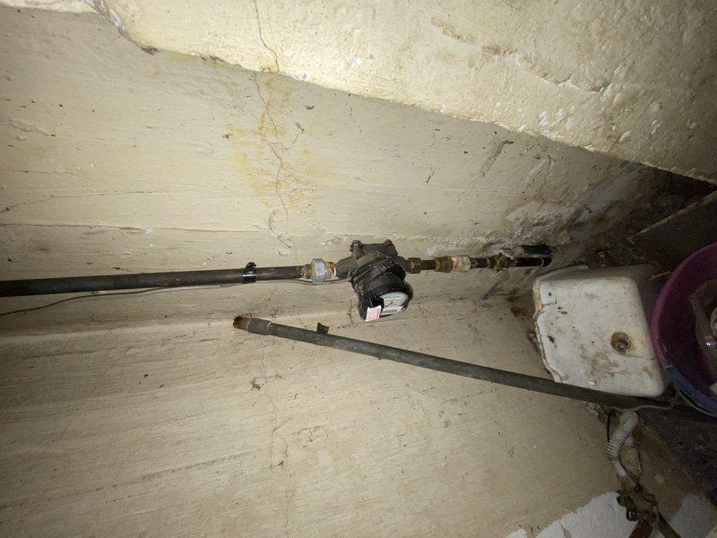 Responded to service call for water heater producing only lukewarm water. Upon inspection of basement utility area, assessed existing water heater condition and determined replacement was necessary. Job temporarily cancelled as installation requires two-person crew due to access constraints and equipment handling requirements. Identified need for sheet metal fabrication to cover existing hole in basement wall prior to installation. Coordinated delivery of new 40-gallon tall gas water heater with 3/4" pressure relief valve to warehouse location. Verified permit requirements with City of University City—no permit sticker required for this installation. Documented existing conditions including aged wooden flooring, concrete block walls, and current plumbing configuration. Photographed existing water heater setup and surrounding utility space for installation planning purposes. Job scheduled for completion upon crew availability and sheet metal preparation.