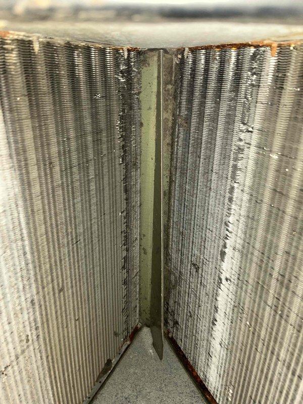 Responded to water leak complaint on basement HVAC unit. Upon inspection, found evaporator coil heavily contaminated with dirt, dust, and biological growth causing drainage issues from the condensate pan. Cleaned evaporator coil assembly, cleared condensate drain line, and verified proper drainage flow. System tested and operating normally with no further water leakage observed.