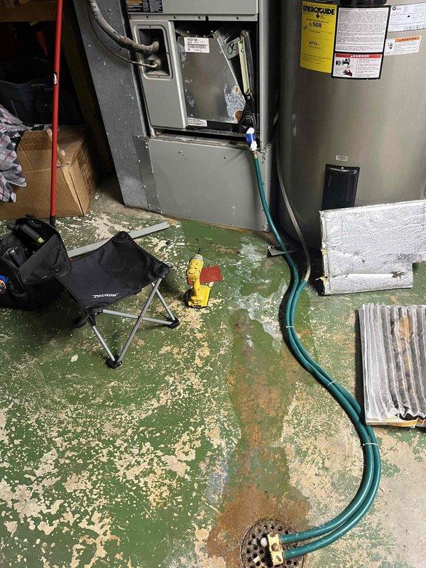 Responded to water leak complaint on basement HVAC unit. Upon inspection, found evaporator coil heavily contaminated with dirt, dust, and biological growth causing drainage issues from the condensate pan. Cleaned evaporator coil assembly, cleared condensate drain line, and verified proper drainage flow. System tested and operating normally with no further water leakage observed.