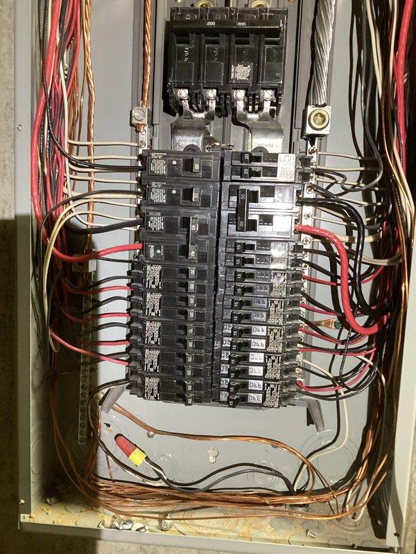 Responded to report of kitchen lights flickering when air conditioning unit activates. Inspected main electrical panel and identified loose neutral connections causing voltage fluctuations during high-load startup conditions. Tightened all neutral bus bar connections, verified proper torque specifications on main breaker terminals, and confirmed all branch circuit connections were secure. Tested system operation through multiple A/C cycling events to verify flickering issue was resolved and electrical system remained stable under load.