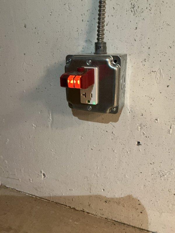 Completed electrical fixture installation in basement area per approved estimate. Installed new electrical wiring through floor joists using appropriate cable routing methods with securing clips and junction boxes. Mounted electrical switch assembly with indicator lights in metallic junction box on foundation wall, utilizing flexible conduit for proper wire protection. All work performed to code specifications with proper grounding and secure mounting hardware.