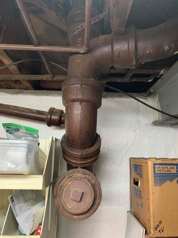 Responded to a clogged drain call at a 70-year-old residential property. Upon inspection, located heavily corroded cast iron drain stack in basement with significant rust deterioration throughout the vertical piping system. Accessed cleanout port on main drain line and cleared obstruction using mechanical augering equipment. Inspected exterior drain access point beneath deck structure, removing accumulated debris and vegetation that had infiltrated the system. Successfully restored proper drainage flow and confirmed clearance with water test.