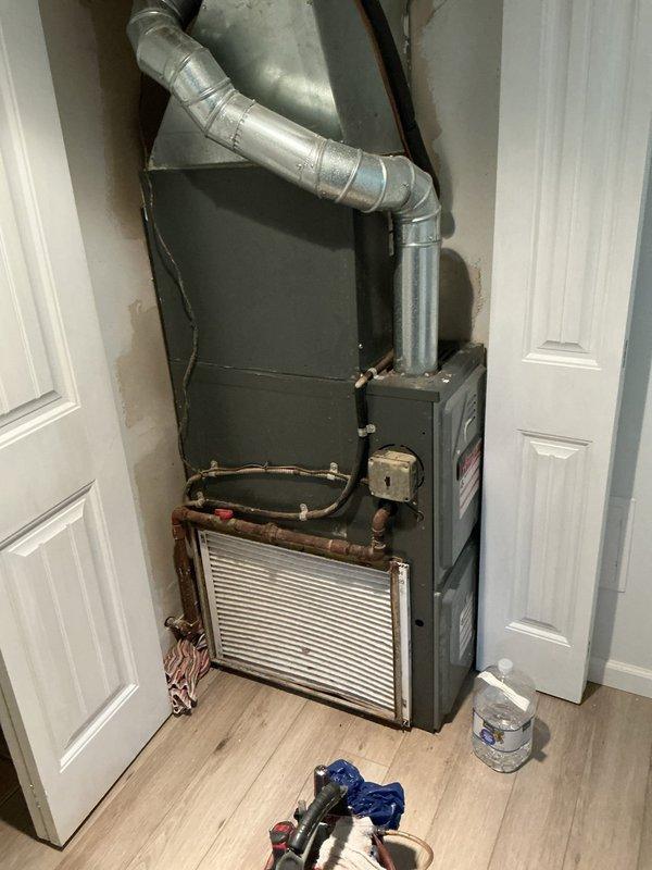 Responded to water leak complaint on 15-year-old residential split AC system. Upon arrival, inspected indoor air handler unit located in utility closet and outdoor Distinction brand condenser unit. Identified source of water leak at indoor unit. Cleared condensate drain line obstruction and verified proper drainage flow. Inspected evaporator coil drain pan for cracks or damage, confirmed integrity. Checked refrigerant lines and insulation for condensation issues. Tested system operation and confirmed no further leaking. Documented equipment condition with photographs of both indoor and outdoor units for service records.