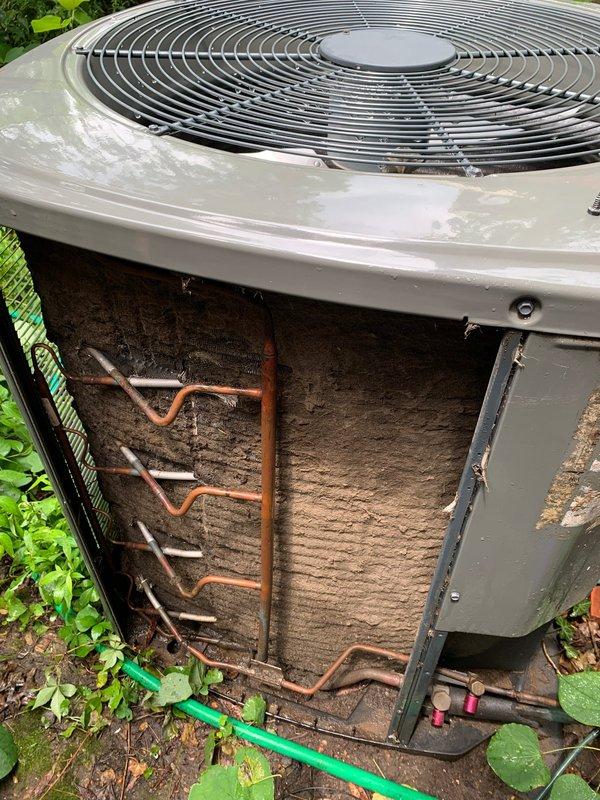 Responded to no-cool call on residential air conditioning system less than 10 years old. Upon arrival, found outdoor condenser unit not operating. Inspection revealed heavily soiled condenser coils with significant accumulation of dirt, dust, and debris restricting airflow through the heat exchanger. Removed side access panel to assess internal components and confirmed extensive buildup on both interior and exterior coil surfaces. Copper refrigerant lines showed signs of normal aging and oxidation. The dense coating on coil fins was impacting system performance and preventing proper heat transfer, which contributed to the unit's failure to operate efficiently. Advised customer to keep unit off and leave fan running until cleaning could be completed to prevent potential compressor damage from reduced airflow conditions.