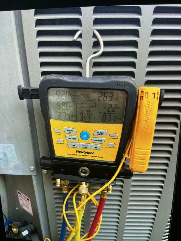 Responded to no cooling complaint on 10+ year old residential air conditioning unit located on side of home. Customer reported thermostat set at 72°F but displaying 75°F, with unusual noise coming from basement equipment. Upon arrival, performed comprehensive system diagnostics using digital manifold gauges to measure refrigerant pressures and temperatures across the system. Connected Fieldpiece manifold to service ports and monitored high-side and low-side pressures while system was operating. Evaluated superheat and subcooling values to determine refrigerant charge status and system performance. Inspected condenser unit and basement air handler for source of reported noise. Measurements indicated system performance issues requiring further evaluation. Documented system readings and equipment conditions with photographic evidence for customer records.