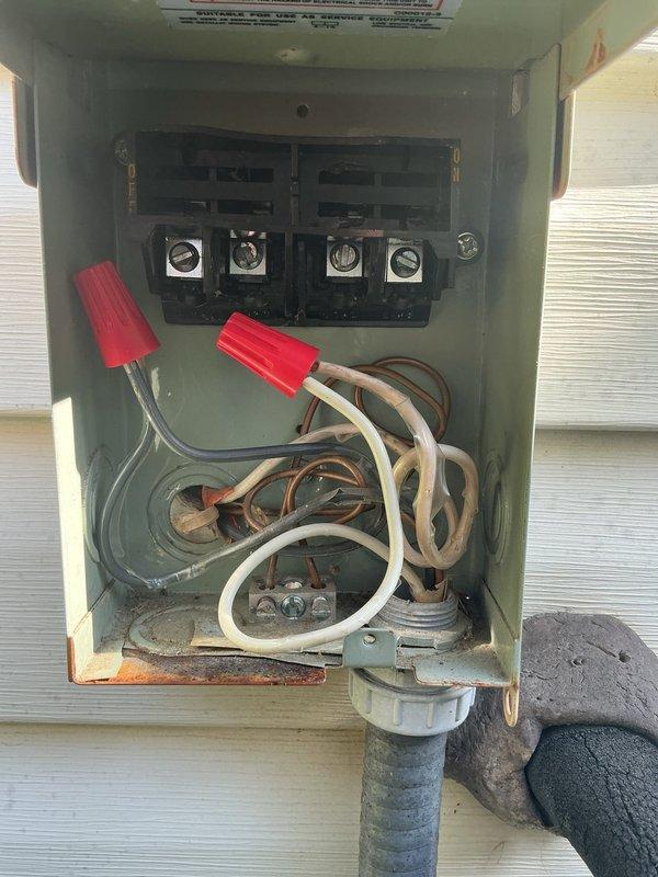 Responded to a no cooling call where the air conditioning unit was running continuously. Upon inspection, discovered that a previous contractor had caused an electrical arc at the disconnect, which damaged the thermostat wiring and components. Evaluated the exterior disconnect box and found compromised wiring connections with evidence of electrical damage. Provided a second opinion assessment and presented options for installing a new code-compliant disconnect box with proper materials to restore safe system operation and resolve the continuous run condition caused by the thermostat failure.