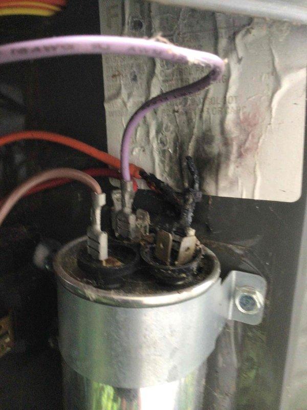 Responded to no cooling complaint on 5-year-old ground-level unit. Upon inspection, found failed run capacitor with severe heat damage, visible burn marks, and charred terminal connections affecting compressor operation. Replaced damaged capacitor, verified proper electrical connections, and restored system to normal cooling operation.