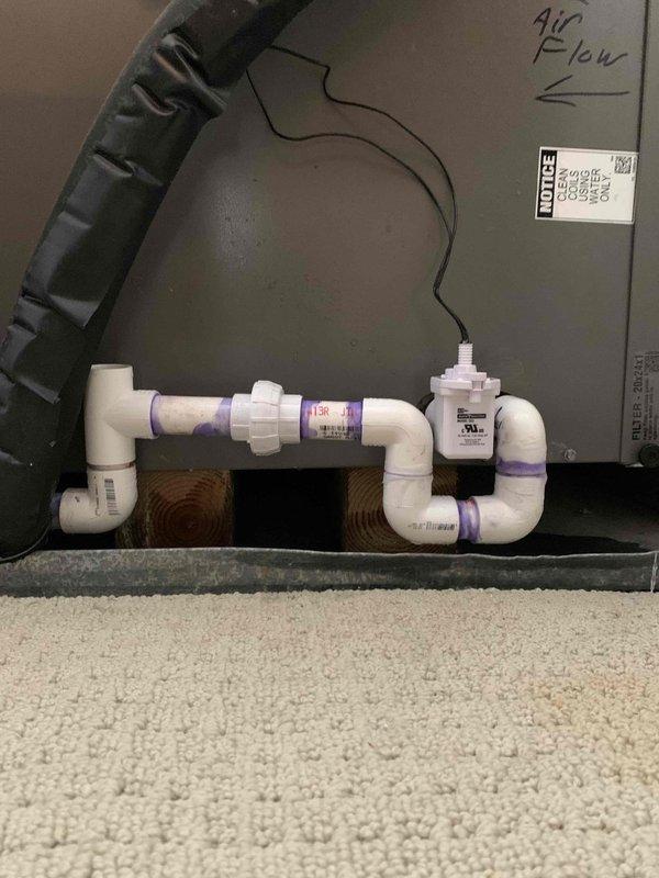 Returned to complete installation by redoing condensate drain PVC piping with proper fittings and connections, and installed SafeT switch on air handler unit. Removed and replaced previous drain line assembly with corrected configuration to ensure proper condensate removal and system protection.