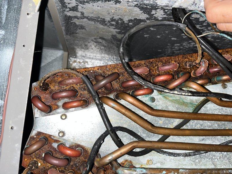 Responded to no cooling complaint on 16-year-old basement unit. Upon inspection, discovered severe corrosion and rust throughout the evaporator coil assembly, with heavy deterioration on copper U-bends and heat exchanger tubes. The extensive corrosion has compromised the coil integrity, resulting in loss of cooling capacity. Recommended complete evaporator coil replacement due to the advanced state of deterioration and provided repair options to restore system functionality.
