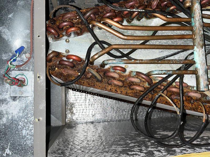 Responded to no cooling complaint on 16-year-old basement unit. Upon inspection, discovered severe corrosion and rust throughout the evaporator coil assembly, with heavy deterioration on copper U-bends and heat exchanger tubes. The extensive corrosion has compromised the coil integrity, resulting in loss of cooling capacity. Recommended complete evaporator coil replacement due to the advanced state of deterioration and provided repair options to restore system functionality.