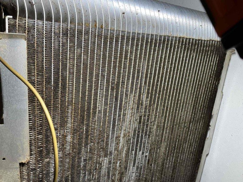 Responded to callback regarding inadequately cleaned filters and clogged evaporator coil on hallway unit. Upon inspection, found evaporator coil heavily contaminated with dust, dirt, debris, and hair buildup throughout aluminum fins, significantly restricting airflow. Coil showed extensive accumulation between fin spaces, particularly in center and lower sections, causing reduced system performance. Documented coil condition with photographs showing dark discoloration and blockage throughout heat exchanger assembly. Addressed customer concerns regarding maintenance quality and provided guidance on proper cleaning procedures for severely impacted coil assembly.